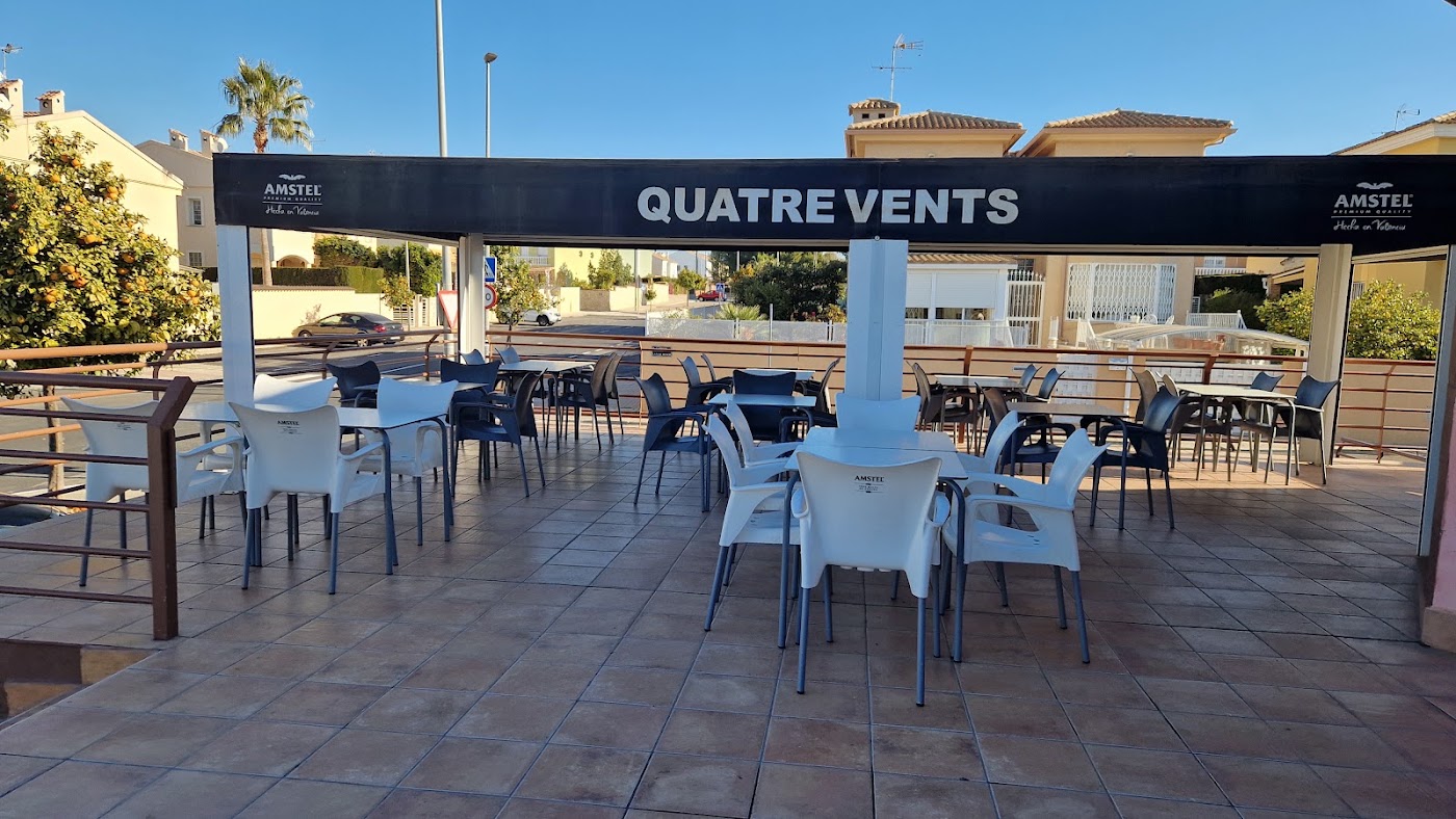 Terraza del Bar Quatre Vents con mesas y sillas bajo un toldo
